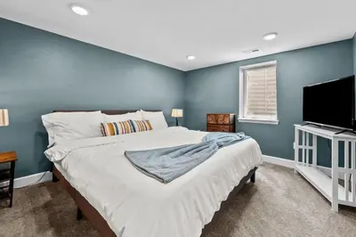 a bedroom with a large bed and a flat screen tv at 5632 Field St in Arvada