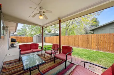 a screened porch with red chairs and a table at 5632 Field St in Arvada