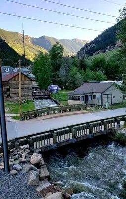 a bridge over a river next to a mountain at Clear Creek Inn in Georgetown