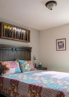 a bedroom with a bed with a wooden headboard at Clear Creek Inn in Georgetown