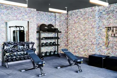 a gym with dumbbells on a wall with wallpaper at Hyatt Centric Downtown Denver in Denver