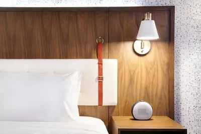 a bedroom with a bed and a clock on a table at Hyatt Centric Downtown Denver in Denver