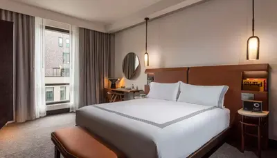 a hotel room with a large white bed and a window at Thompson Denver, by Hyatt in Denver