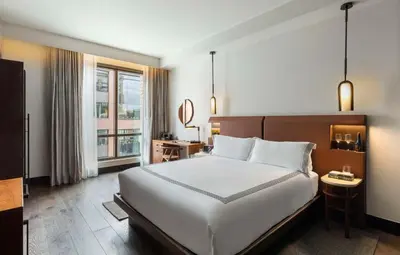 a bedroom with a large bed and a large window at Thompson Denver, by Hyatt in Denver