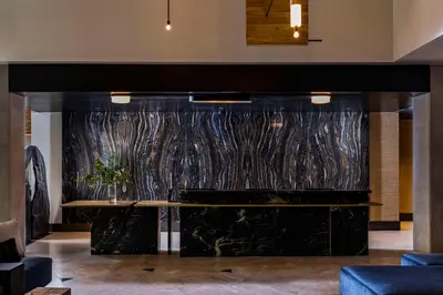 a lobby with a large marble wall with a table at Thompson Denver, by Hyatt in Denver