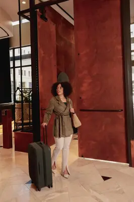 a woman standing next to a door with a suitcase at Thompson Denver, by Hyatt in Denver