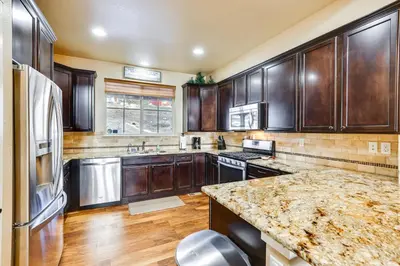 a kitchen with wooden cabinets and a granite counter top at Spacious Granby Home with Views Less Than 2 Mi to Ski and Golf in Granby