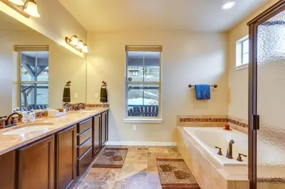 a bathroom with two sinks and a tub and a shower at Spacious Granby Home with Views Less Than 2 Mi to Ski and Golf in Granby
