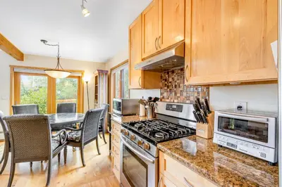 a kitchen with wooden cabinets and a table with chairs at Mountain Vistas in Silverthorne