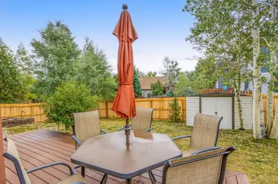 a table and chairs with an umbrella on a deck at Mountain Vistas in Silverthorne