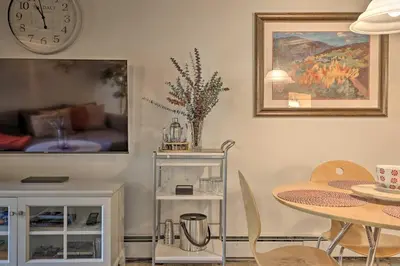 a dining room with a table and a clock on the wall at Ski Shuttle and Pool Modern Silverthorne Condo! in Silverthorne