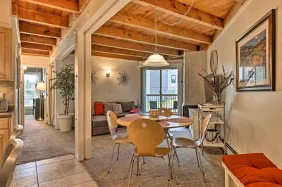 a dining room and living room with a table and chairs at Ski Shuttle and Pool Modern Silverthorne Condo! in Silverthorne