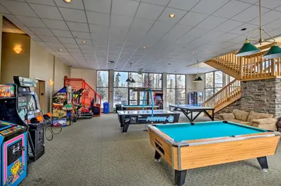 a room with a pool table and arcade games at Ski Shuttle and Pool Modern Silverthorne Condo! in Silverthorne
