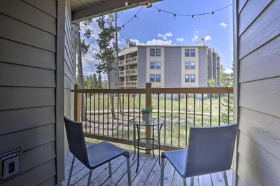 a balcony with two chairs and a table and a building at Ski Shuttle and Pool Modern Silverthorne Condo! in Silverthorne