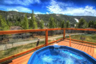 a hot tub on a deck with a view of the mountains at Frostfire D24 condo in Keystone
