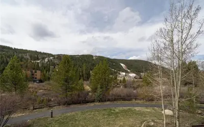 a road in the middle of a field with a mountain at Frostfire D24 condo in Keystone