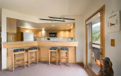a kitchen with a bar with four stools at Frostfire D24 condo in Keystone