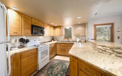 a large kitchen with wooden cabinets and white appliances at Frostfire D24 condo in Keystone