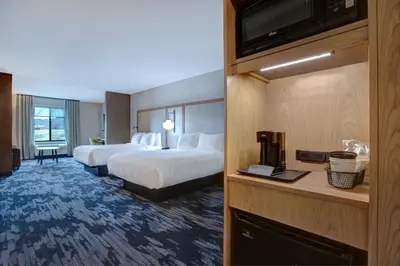 a hotel room with two beds and a television at Fairfield by Marriott Inn & Suites Denver Southwest, Littleton in Littleton