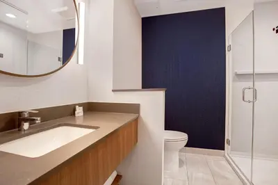 a bathroom with a sink and a toilet and a mirror at Fairfield by Marriott Inn & Suites Denver Southwest, Littleton in Littleton