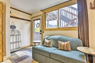 a living room with a blue couch and a window at Keystone Mountain Getaway Walk to Ski Lifts in Keystone