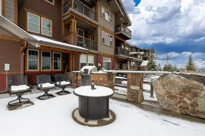 a snow covered patio with chairs and a building at Cozens Pointe I-101 condo in Fraser