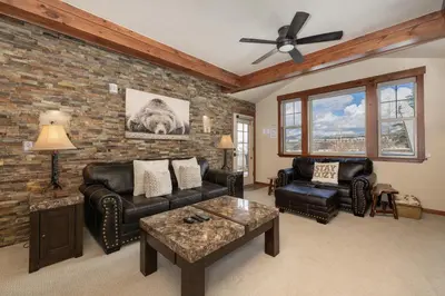 a living room with leather furniture and a brick wall at Cozens Pointe I-101 condo in Fraser