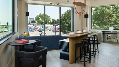 a restaurant with a bar with stools and a couch at Catbird Hotel in Denver