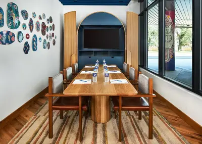 a conference room with a long wooden table and chairs at Catbird Hotel in Denver