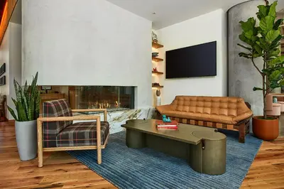 a living room with a couch and a fireplace at Catbird Hotel in Denver