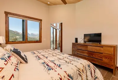 a bedroom with a bed and a tv and a window at Azure Vista Vacation Home at Windcliff home in Estes Park