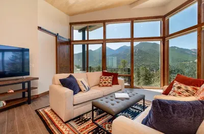 a living room with couches and a tv and mountains at Azure Vista Vacation Home at Windcliff home in Estes Park