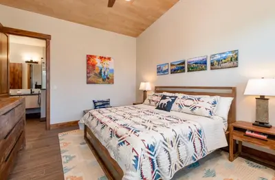 a bedroom with a bed and a table with a lamp at Azure Vista Vacation Home at Windcliff home in Estes Park