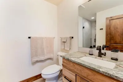 a bathroom with a sink and a toilet and a mirror at Azure Vista Vacation Home at Windcliff home in Estes Park