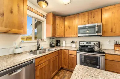 a kitchen with wooden cabinets and a stove top oven at Serenity in the Rockies townhouse in Estes Park