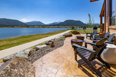 a row of benches sitting next to a lake at Private Lakefront Cabin - Two Large Patios, Jacuzzi, Indoor/Outdoor Fireplace in Estes Park