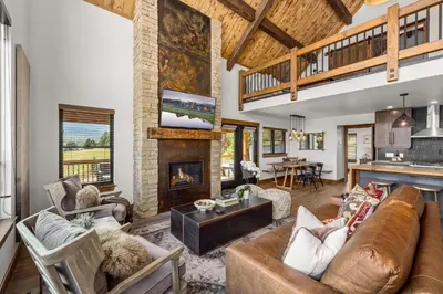 a living room with a couch and a fireplace at Private Lakefront Cabin - Two Large Patios, Jacuzzi, Indoor/Outdoor Fireplace in Estes Park