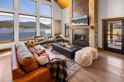 a living room with a couch and a fireplace at Private Lakefront Cabin - Two Large Patios, Jacuzzi, Indoor/Outdoor Fireplace in Estes Park