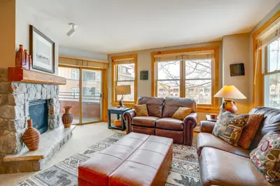 a living room with leather furniture and a fireplace at Ski-InandOut Condo with Hot Tub Access in Keystone! in Keystone