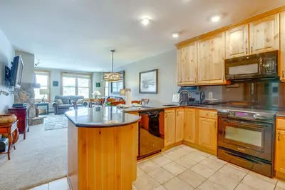 a large kitchen with wooden cabinets and a counter top at Ski-InandOut Condo with Hot Tub Access in Keystone! in Keystone