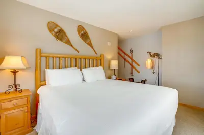 a bedroom with a large white bed and two lamps at Ski-InandOut Condo with Hot Tub Access in Keystone! in Keystone
