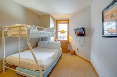 a bedroom with a bunk bed and a tv at Ski-InandOut Condo with Hot Tub Access in Keystone! in Keystone