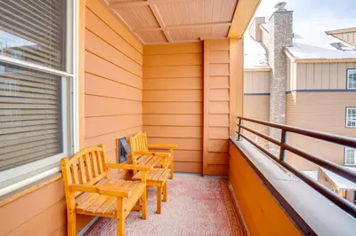 two chairs on the balcony of a house at Ski-InandOut Condo with Hot Tub Access in Keystone! in Keystone