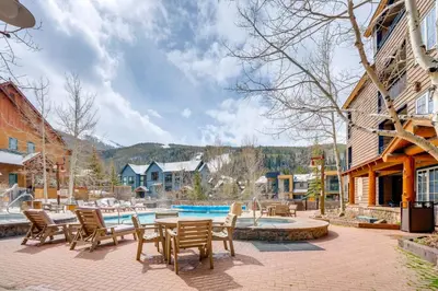 a patio with tables and chairs next to a pool at Ski-InandOut Condo with Hot Tub Access in Keystone! in Keystone