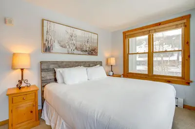a bedroom with a white bed and a window at Ski-InandOut Condo with Hot Tub Access in Keystone! in Keystone