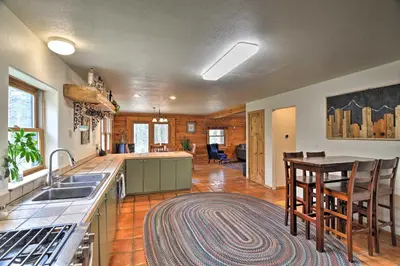 a kitchen with a sink and a table with chairs at The Pinecone Palace with Hiking Trail Access! in Lyons