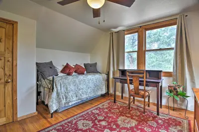 a bedroom with a bed with a desk and a window at The Pinecone Palace with Hiking Trail Access! in Lyons