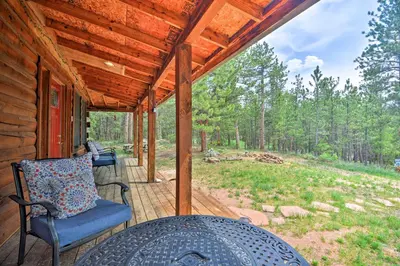 a porch of a cabin with a table and chairs at The Pinecone Palace with Hiking Trail Access! in Lyons