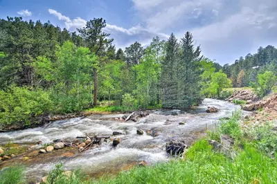 a river with rapids in the middle of a forest at The Pinecone Palace with Hiking Trail Access! in Lyons