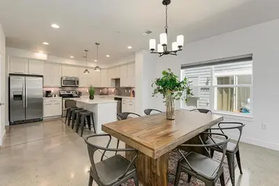 a large kitchen with a wooden table and chairs at Gorgeous Townhome Steps from the Brewery District! in Fort Collins